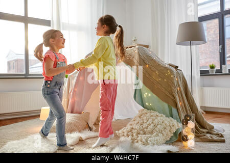 happy girls playing near kids tent at home Stock Photo