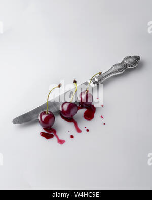 Natural cherry cuts the old knife oreginalny concept. View from the top and side. Stock Photo