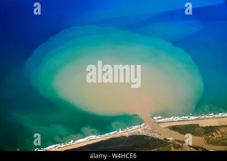 A dark muddy river flowing into the sea in a shape of a tree aerial colorful photo of African coastline Stock Photo