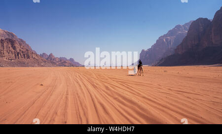 Bedouin with camel in the middle of Wadi Rum Desert in Jordan Stock Photo