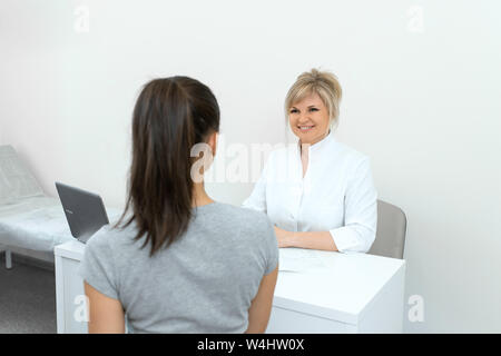 Beautiful woman gynecologist is conducting a reception with a young girl. Consultations and help gynecologist. Stock Photo