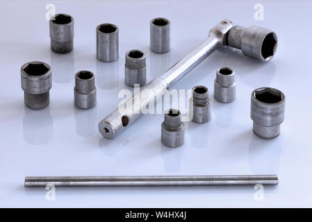A universal set of tool heads with a ratchet for the car in on a glossy light gray background, close-up. Stock Photo