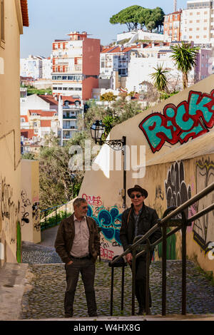 Two men and extensive graffiti on Caracol da Graça, a steep pedestrian lane in Graça, Lisbon, Portugal.  MODEL RELEASED Stock Photo
