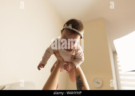 Young mother and baby are in bed. Mom and baby are playing at home. Authentic lifestyle photos. Stock Photo