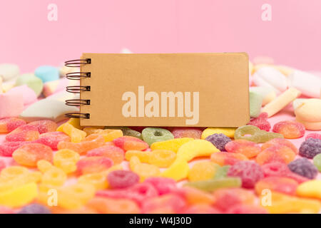 Marshmallow and blank notepad on pink background. Place for your text. Cozy sweet background Stock Photo