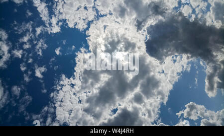 Cumulus clouds against a bright blue sky on a Sunny day. Stock Photo