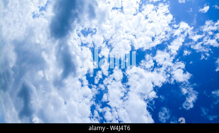 Cumulus clouds against a bright blue sky on a Sunny day. Stock Photo