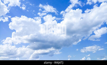 Cumulus clouds against a bright blue sky on a Sunny day. Stock Photo