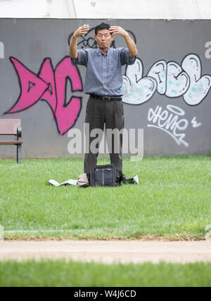 Businessman performing Falun Dafa / Falun Gong /meditation/mindfulness in city park. Stock Photo