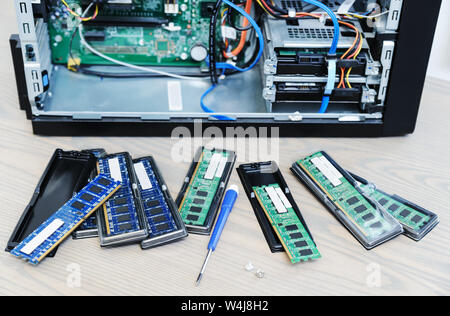 Different RAM slots are on the desktop near the computer. Stock Photo
