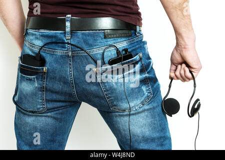 There are a power bank and smartphone in the back pocket of jeans. Stock Photo