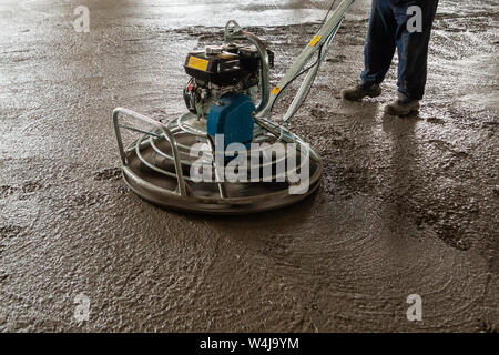 Power float grinder machine on wet concrete background closeup shot with selective focus and boke blur. Stock Photo