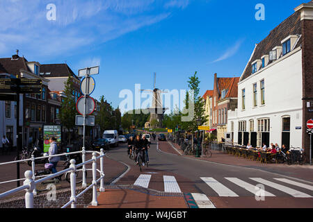 Leiden, Holland, Netherlands, May 22, 2019.  Street view, Molen De Valk museum (Falcon windmill) traditional houses parked bicycles and bicyclists Stock Photo