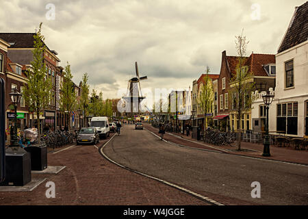 Leiden, Holland, Netherlands, May 22, 2019.  Street view, Molen De Valk museum (Falcon windmill) traditional houses parked bicycles and bicyclists Stock Photo