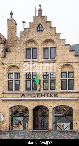 Diksmuide, Flanders, Belgium -  June 19, 2019: Grote Markt. Yellow brick facade with step gable of Pharmacy delplancke shows three bowed window with d Stock Photo