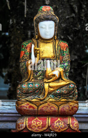 Painted, vintage Chinese Buddha statue at a temple Wat in Chiang Mai, Northern Thailand. Stock Photo