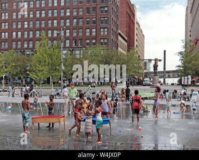 Children play in the water fountains of Public Square in downtown Cleveland, Ohio, USA during the summer.
