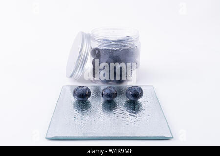 A boat full of blueberries and three on a glass plate - Large sweet blueberries - Isolated on a white background Stock Photo