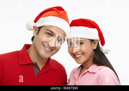 Portrait of a couple wearing Santa hat and smiling Stock Photo