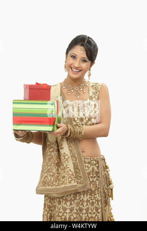 Indian bride holding gift boxes and smiling Stock Photo