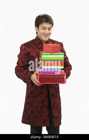 Indian bride holding gift boxes and smiling Stock Photo