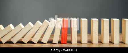 Wooden blocks and the effect of dominoes. Risk management concept. Successful strong business and problem solving. Reliable leader. Stop the destructi Stock Photo