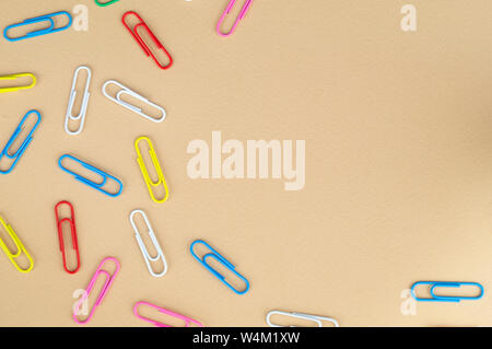 Many colored paper clips on a nice beige background Stock Photo