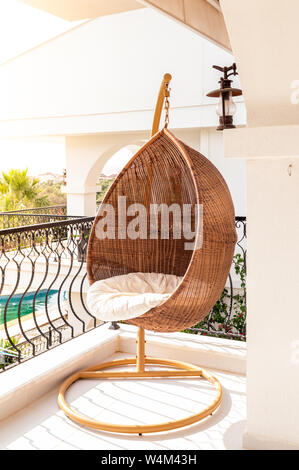 Lounge hanging chair in a balcony on a sunny day. Stock Photo