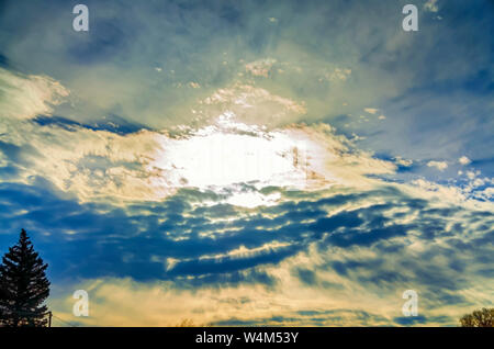 The song and dance between the sun and the clouds to create a dramatic evening sky. Stock Photo