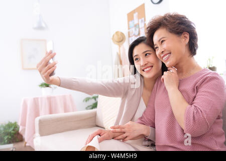 Happy mother and daughter to use mobile phones Stock Photo