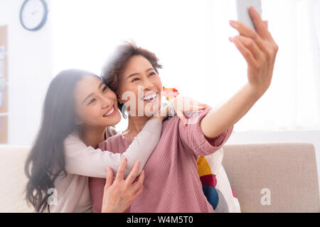 Happy mother and daughter to use mobile phones Stock Photo