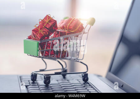 Shopping cart and laptop computer with gift boxes Stock Photo