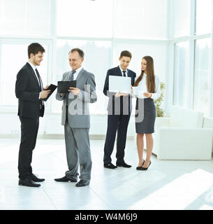 successful business team debating and discussing work in front of a business meeting in the lobby Stock Photo
