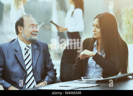 business team is working with financial documents at the office, a discussion between the two partners, the team in the background mode Stock Photo