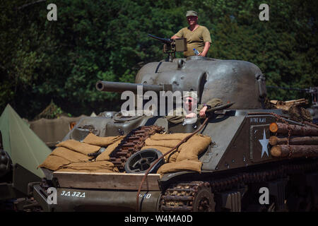 Hop Farm, Tonbridge, Kent, UK. 23rd July, 2019. Two re-enactors driving a Sherman WW2 tank through the Living History section of the War and Peace Revival, 2019. Credit: 6.Media/Alamy Live News Stock Photo