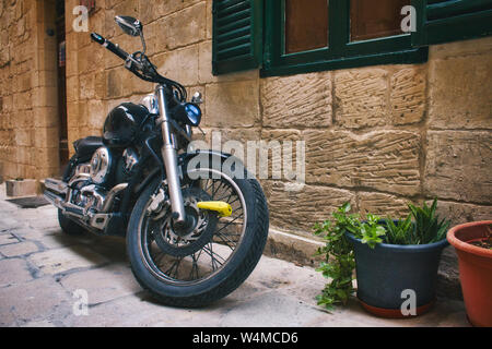 Motorbike parked in front of a Mediterranean rural village house Stock Photo