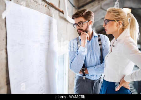 Two architects discussing new project at modern office Stock Photo