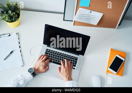 High angle view of unrecognizable man working on laptop in office Stock Photo