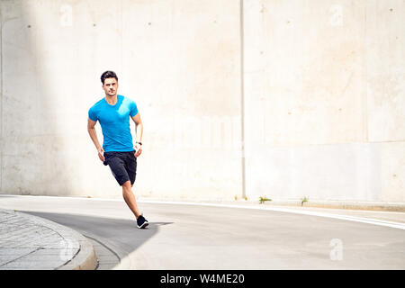 Athletic and handsome man jogging in the city. Sport and fitness concept Stock Photo