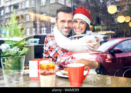 Couple hugging in cafe during christmas and embracing Stock Photo