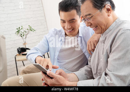 Happy father and son use cellular phones Stock Photo