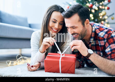 Happy couple opening a Christmas present Stock Photo