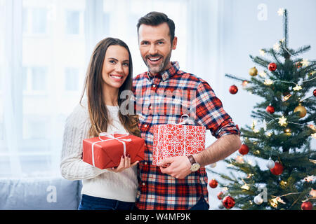 Joyful couple with christmas presents in decorated living room. Portrait of happy family Stock Photo