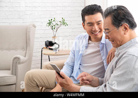 Happy father and son use cellular phones Stock Photo