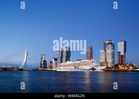 Rotterdam, Netherlands – June 27, 2019: Cruise ship Aida Perla moored at the Wilhelminapier on the Kop van Zuid in Rotterdam at dusk with the Erasmus Stock Photo