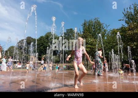 Windsor, UK. 25th July, 2019: UK Weather - young families cope with the heat by cooling down in fountains in Bachelors' Acre in Windsor. Matthew Ashmore/Alamy Live News Stock Photo