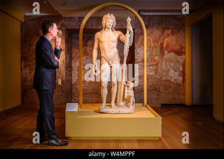 Oxford, UK. 24th July, 2019. LAST SUPPER IN POMPEII exhibition opens at the Ashmolean Museum in Oxford, UK. Dr. Xa Sturgis, Director Ashmolean with Statue of Bacchus AD 50-150 (Roman god of wine and fertility). Credit: Richard Cave/Alamy Live News Stock Photo