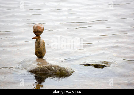 Stone balancing in Loch an Eilein in Rothiemurchus Forest, Cairngorm, Scotland, UK. Stock Photo