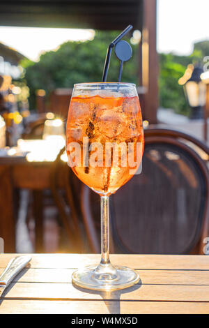 Closeup wine glass of cold cocktail Aperol spritz on background of restaurant. Traditional Italian Aperitif Cocktail concept Stock Photo