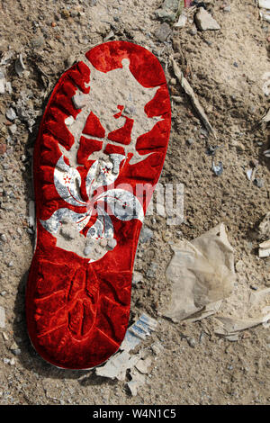 The flag of Hong Kong is depicted on the sole of an old boot. Ecology concept with environmental pollution from household and industrial waste. Stock Photo